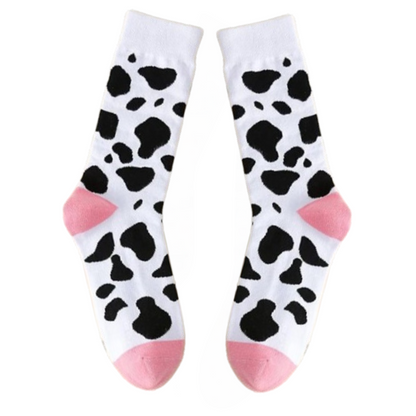 Pair of socks with cow print and pink accents on a white background