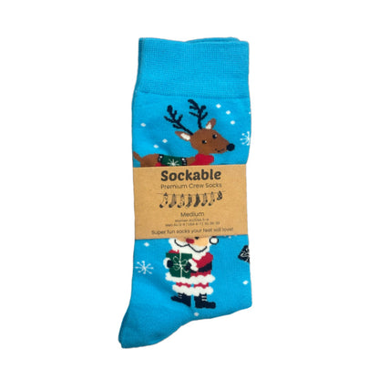 Blue sock with reindeer and Santa Claus design on a white background ith Sockable label